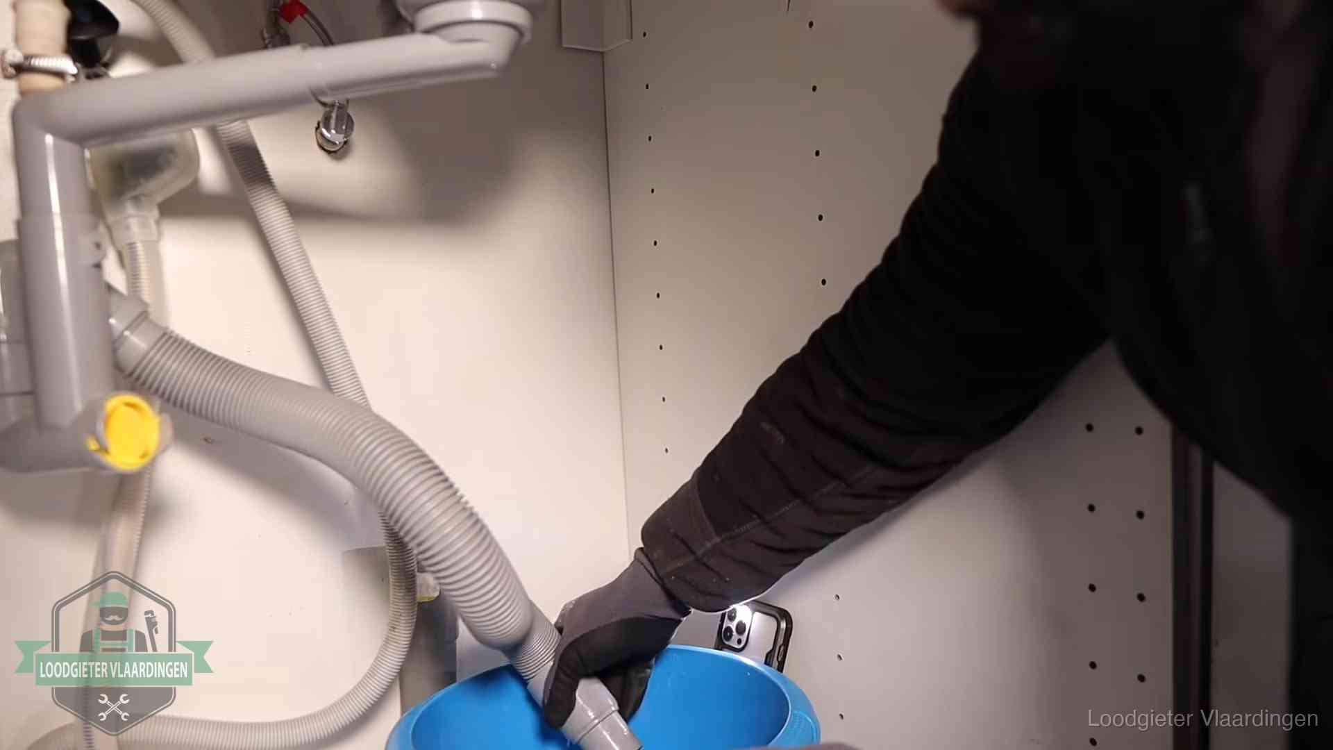Afvoerslang loopt leeg in een emmer onder de gootsteen in Vlaardingen, een klus die je zelf kunt doen