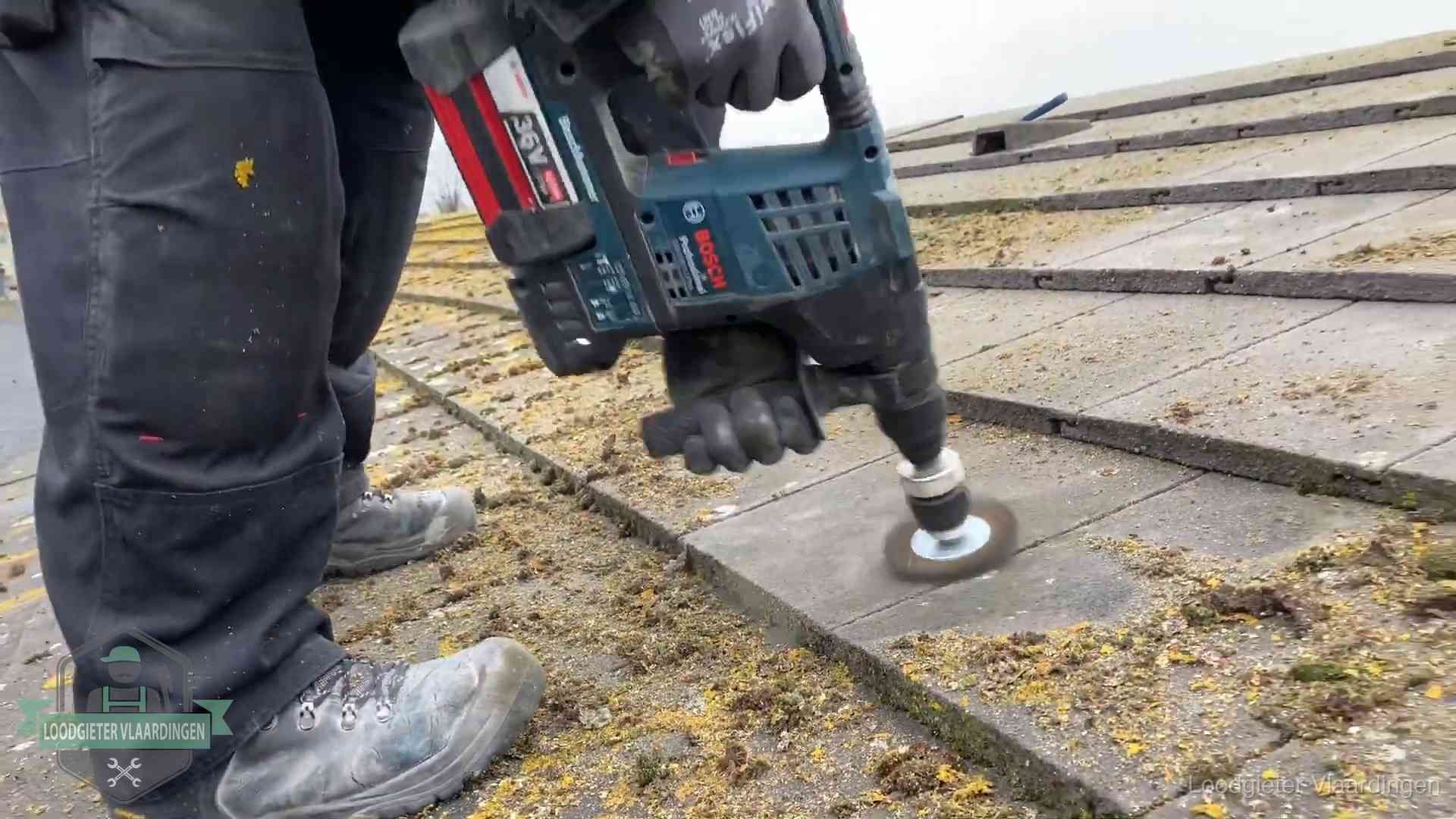 Betonnen dakpannen worden machinaal gereinigd tijdens dakonderhoud in Vlaardingen