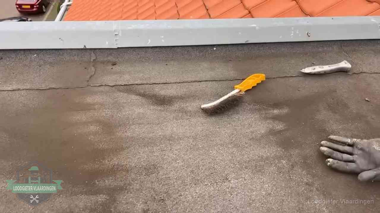 Dakdekker bereidt een bitumen plat dak voor op reparatie bij de daktrim in Vlaardingen