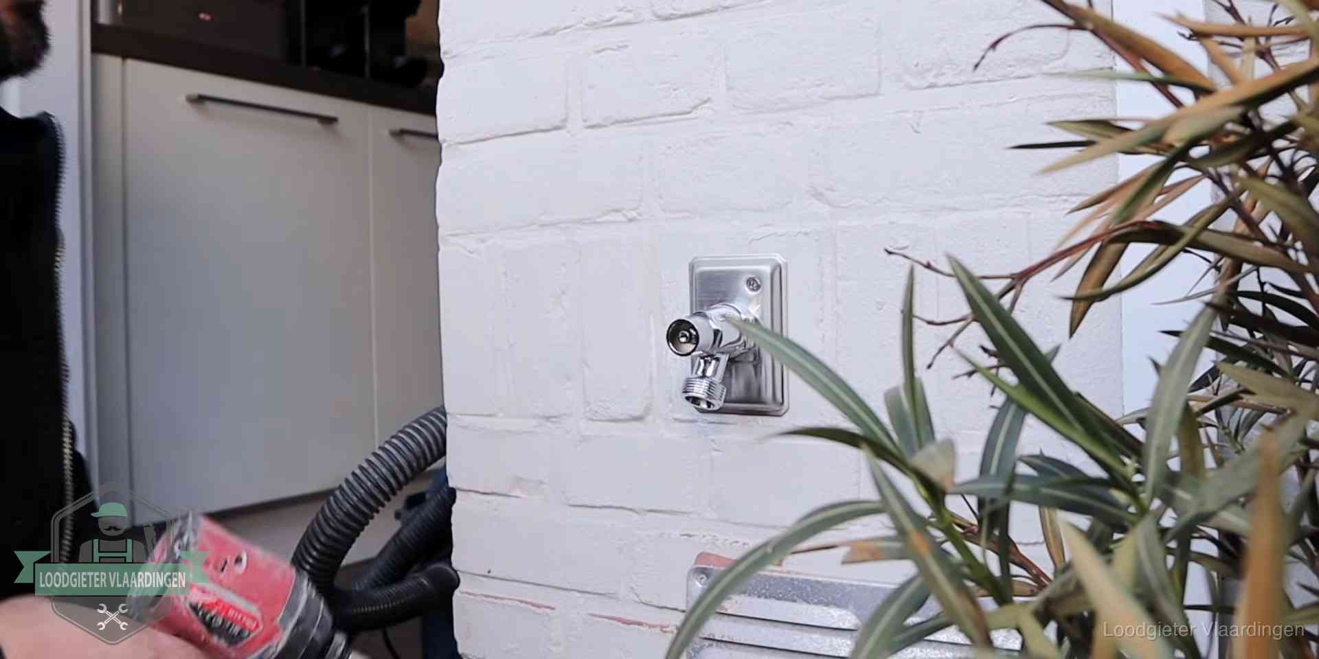 Chromen kraan op een muurplaat bij een woning in Vlaardingen, dichtdraaien is stap een van de lektest