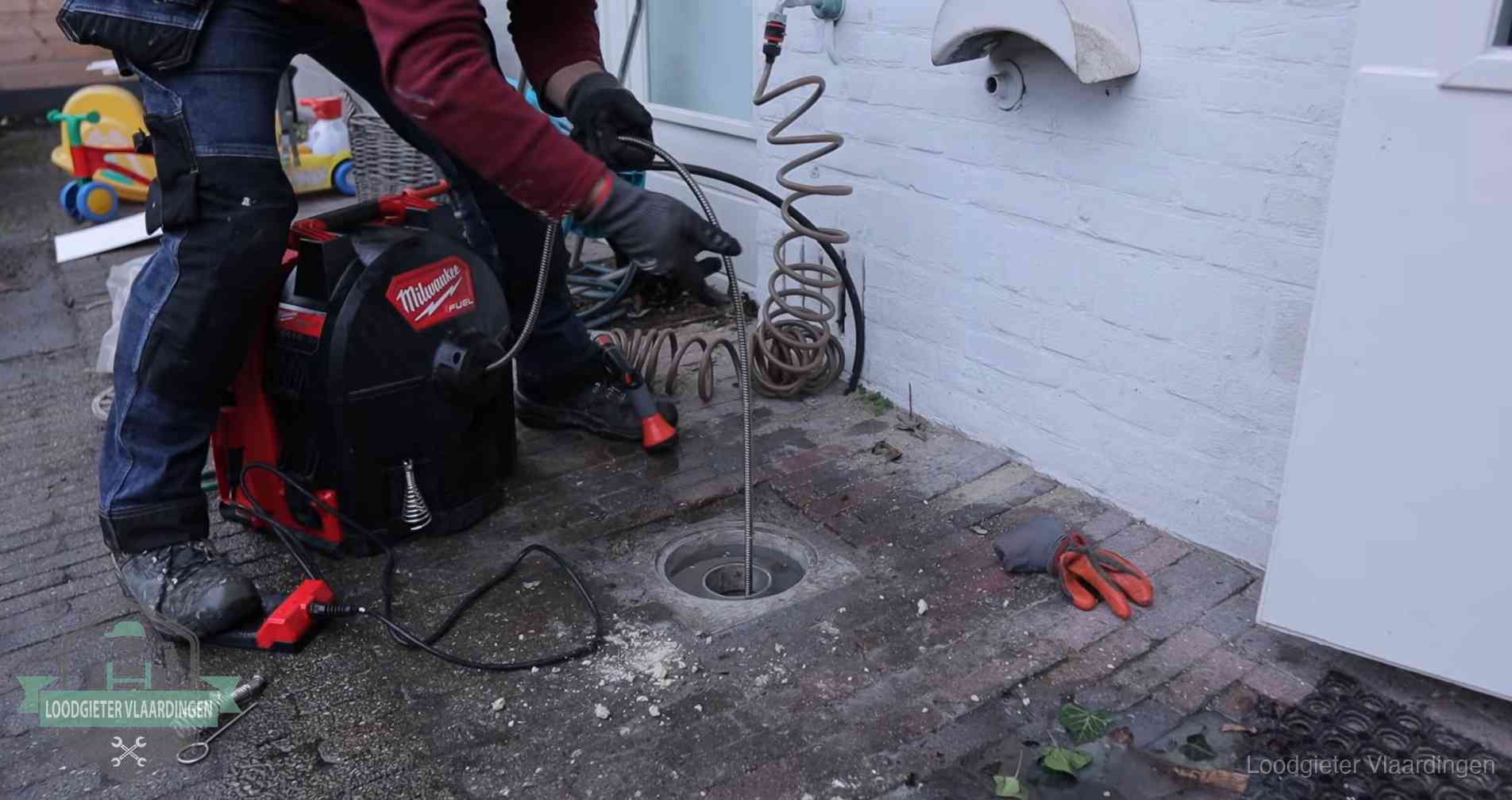 Ontstoppingsputje in de bestrating naast de gevel van een woning in Vlaardingen