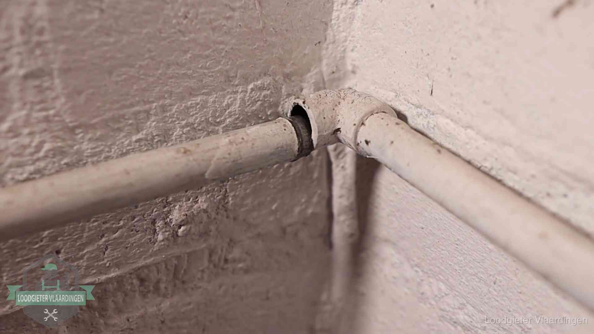 Oude geverfde waterleiding met een losliggende fitting in een woning in Vlaardingen