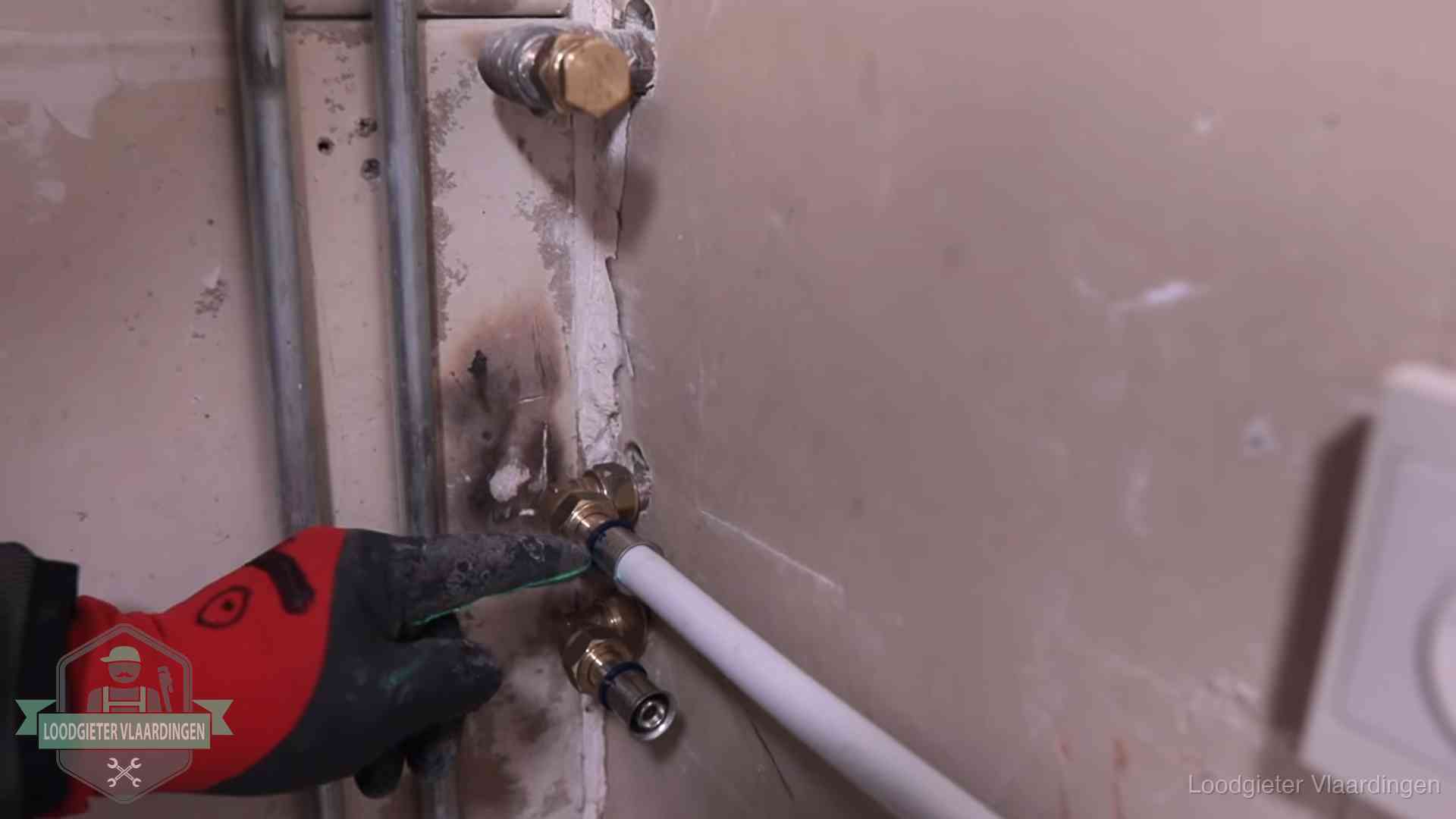 Garantie op loodgieterswerk in Vlaardingen Loodgieter wijst de persfitting op nieuwe muuraansluitingen aan in een woning in Vlaardingen