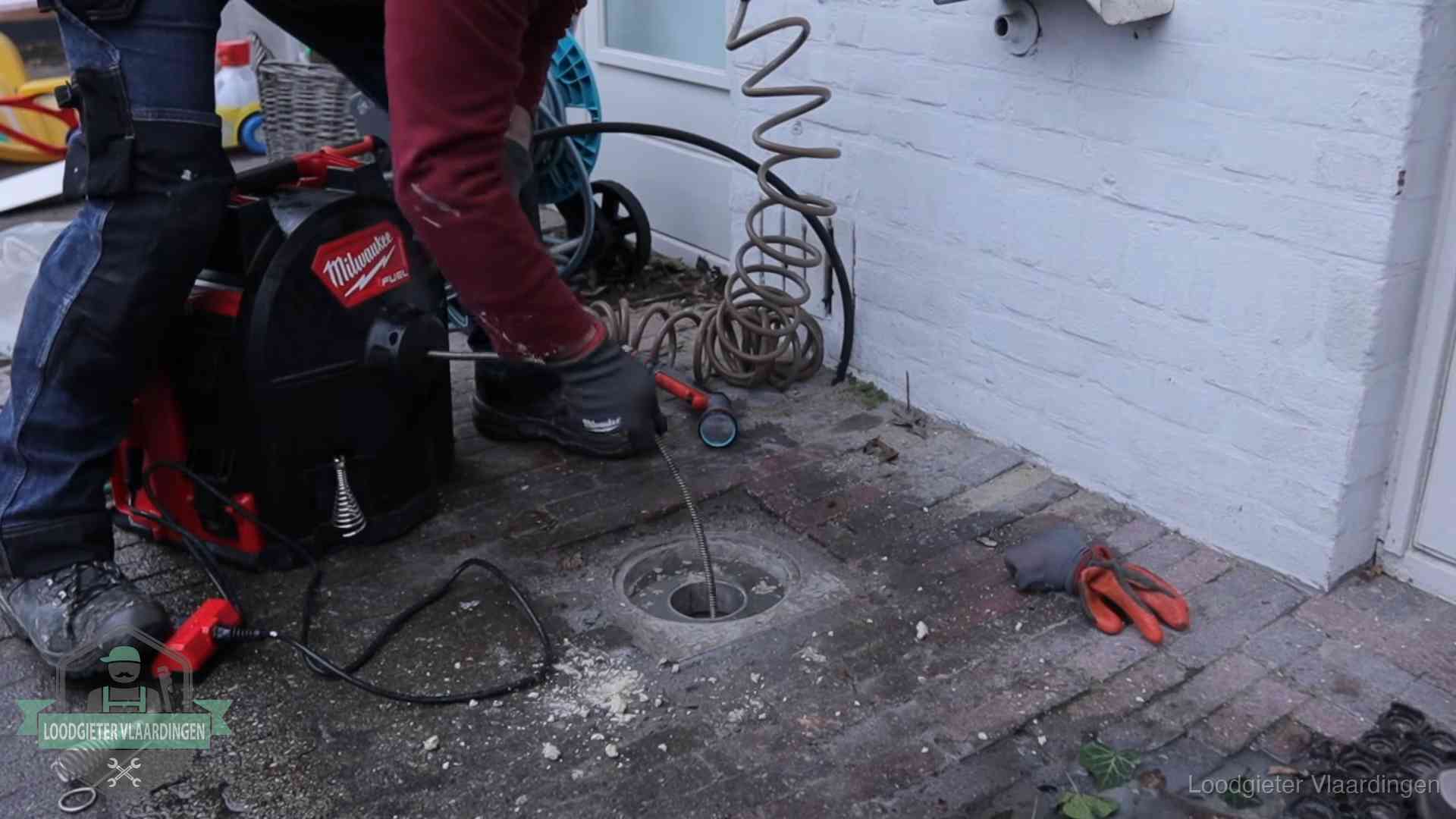 Spiraalmachine bij een ontstoppingsputje in de bestrating in Vlaardingen