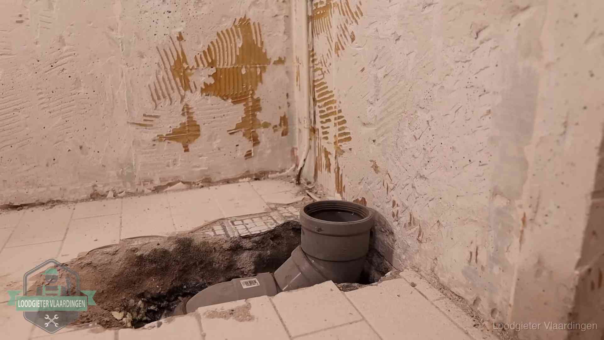 Opengebroken vloer met een nieuwe pvc-rioolbocht in een gegraven sleuf in Vlaardingen